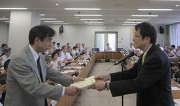 （永田学長から表彰状を受け取る山本幹雄教授）
